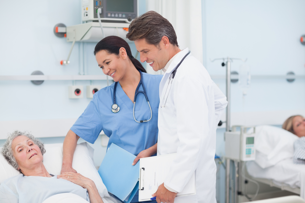 Nurse and doctor next to a patient in hospital ward-1