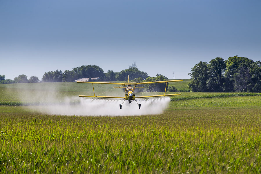 bigstock-A-crop-duster-applies-chemical-97488557